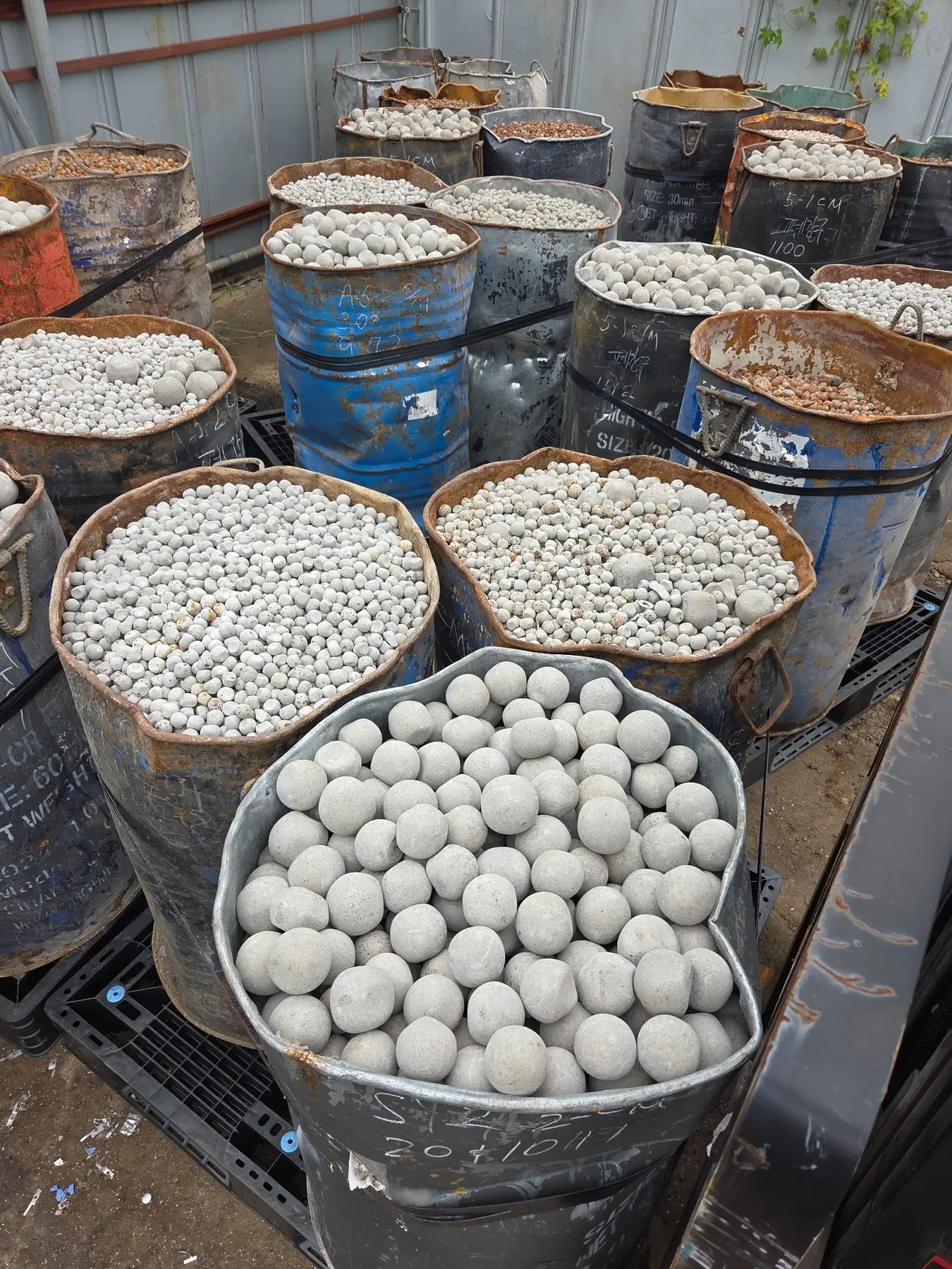 Drums containing mixed-size used grinding media balls
